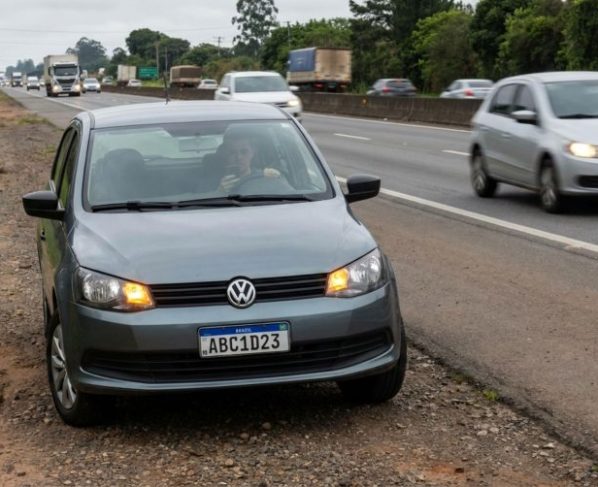 Motorista para o carro no acostamento para atender o celular e descobre que o local não pode ser usado para isso, recebendo multa e pontos na carteira